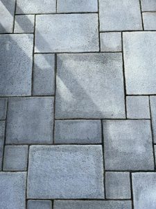 Close-up of a geometric concrete paver pattern with distinct shadows casting an abstract look.