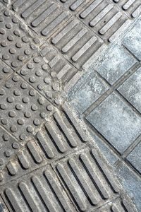 Close-up of textured pavement intersection with various patterned tiles.