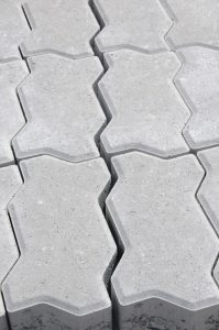 Close-up view of interlocking concrete pavers with a geometric pattern, perfect for outdoor pavements.