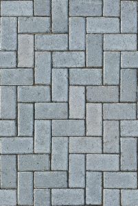 Detailed gray textured pavement with a classic herringbone pattern, ideal for design backgrounds.